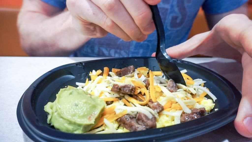 taco bell meal in a take out container being eaten with a spork