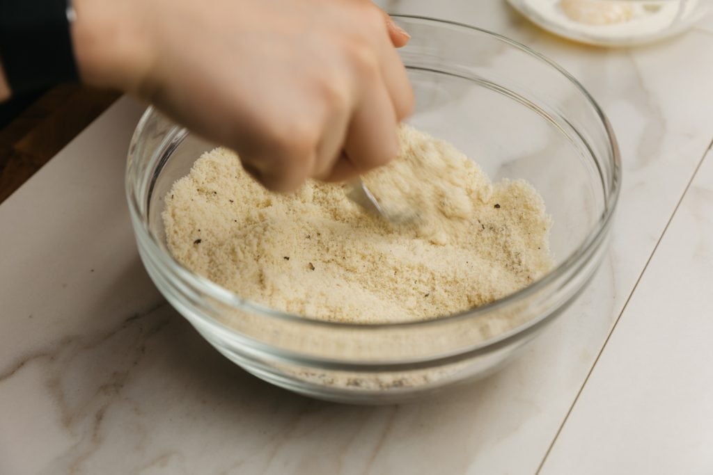 keto chicken tenders mixing together ingredients for the breading mixture