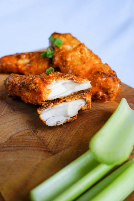 keto chicken tenders coated in buffalo sauce with a side of celery