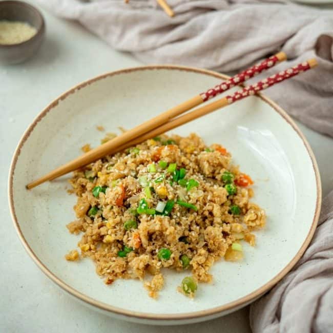 Cauliflower Fried Rice serving of cauliflower fried rice with chopsticks in a bowl