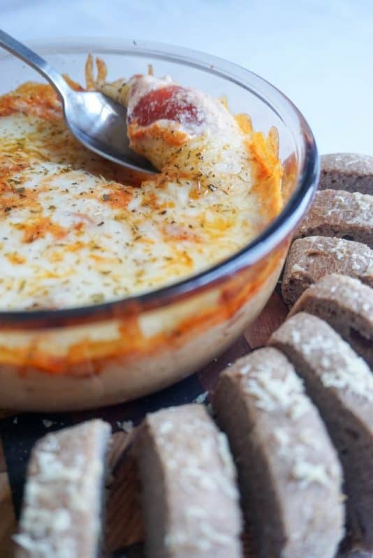 easy keto pizza dip in a bowl with bread for dipping