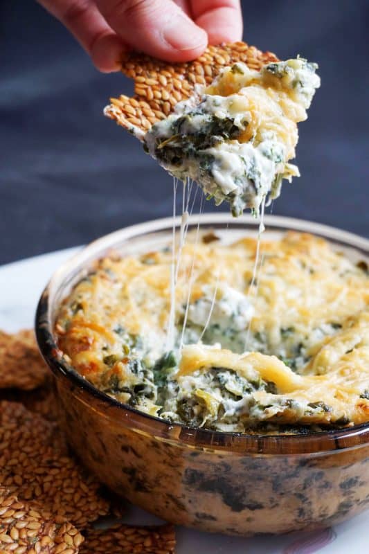 Scooping gooey spinach artichoke dip