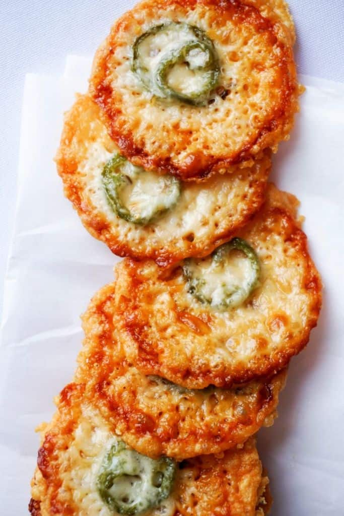 row of parmesan crisps with a single slice of jalapeno baked into each