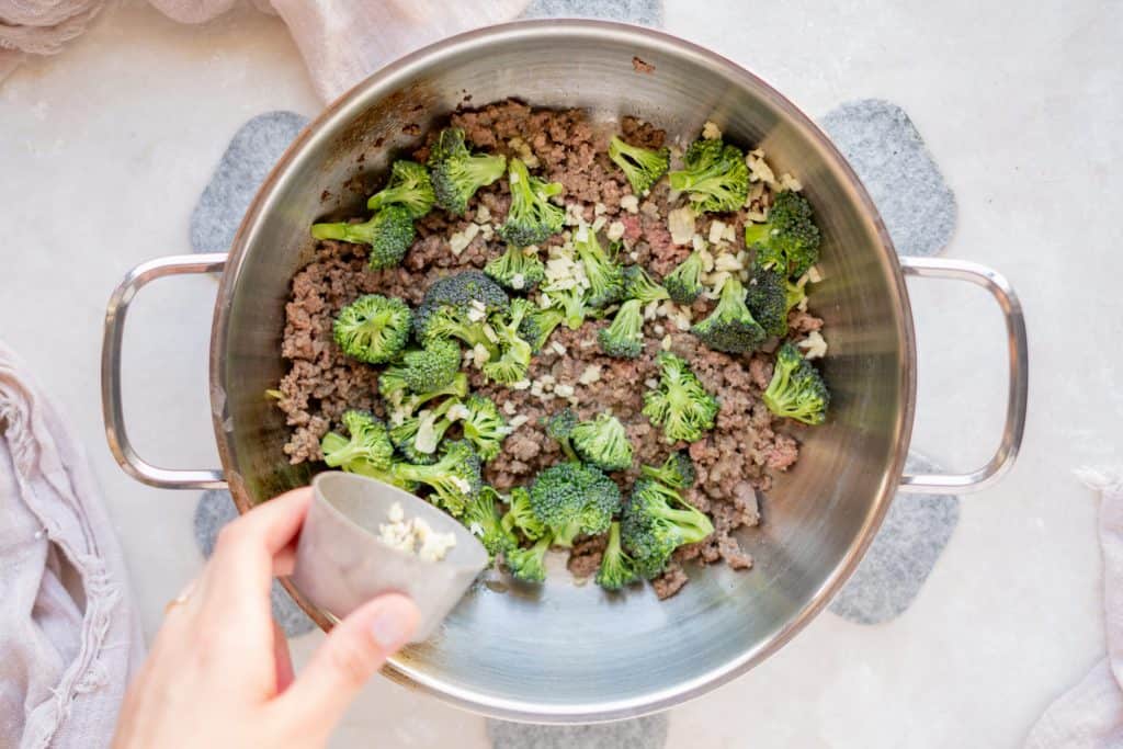 Keto breakfast Casserole Broccoli being added to sausage