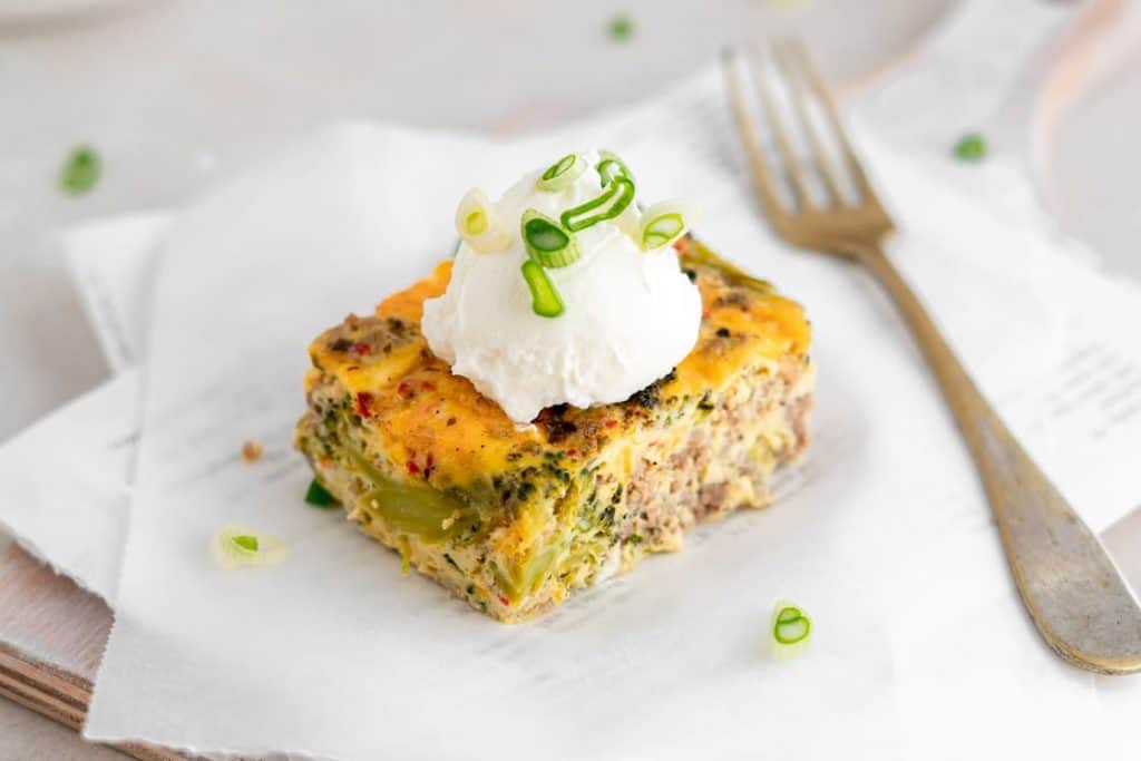 A tarnished fork next to a single piece of breakfast casserole. 