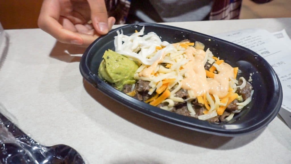 breakfast bowl from taco bell with eggs steak cheddar cheese sour cream and guacamole