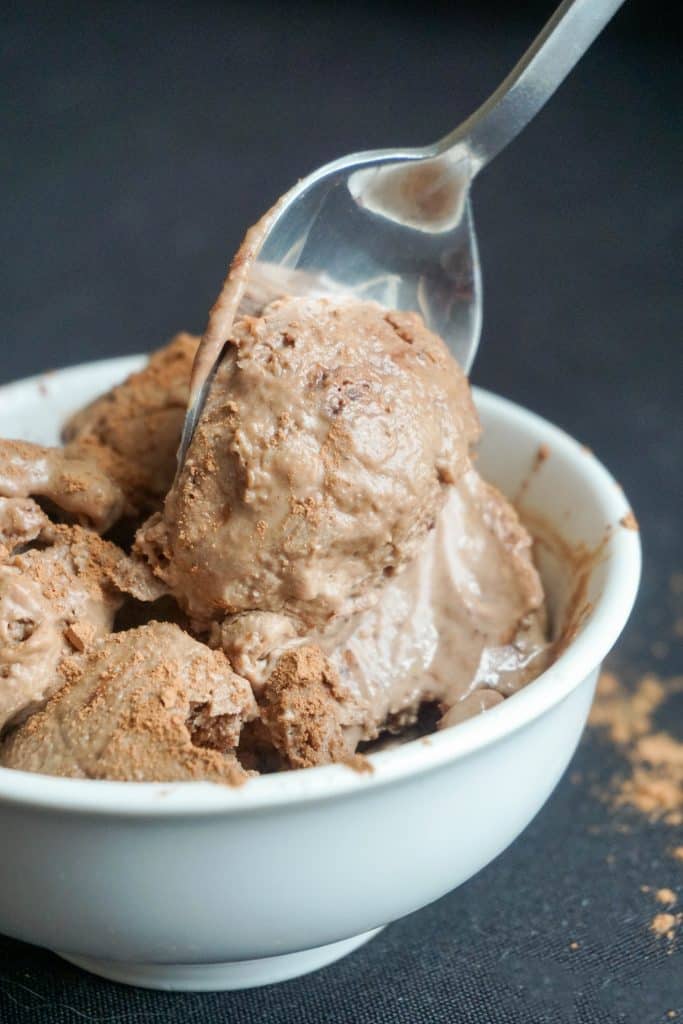 a spoonful of keto chocolate ice cream being taken from a bowl