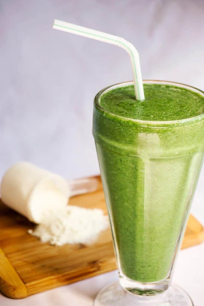 A green smoothie with a straw. 