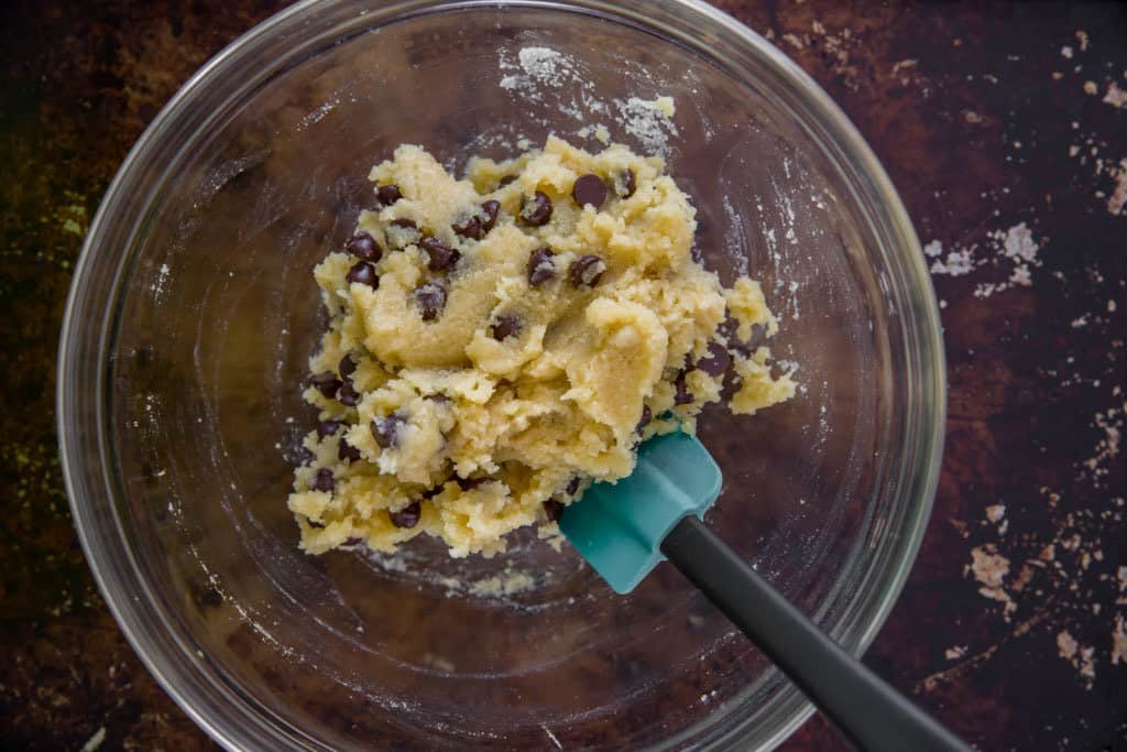 keto chocolate chip cookie dough being mixed and combined with a spatula