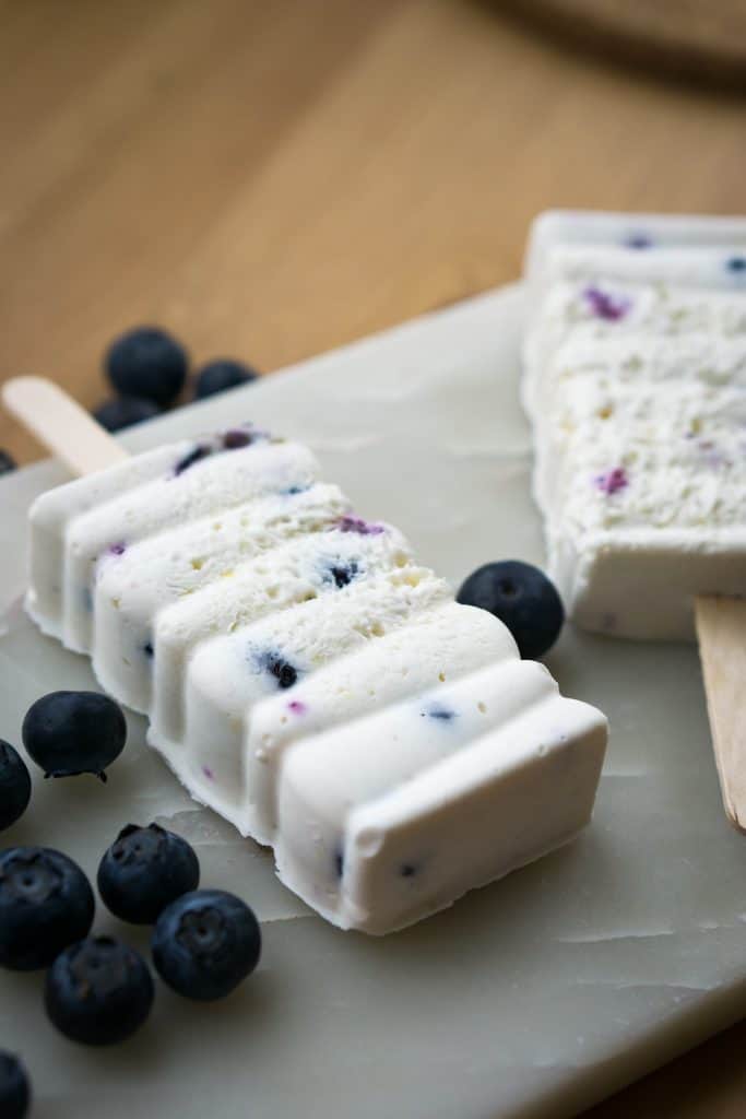 Blueberry cheesecake popsicles on a marble tray. 
