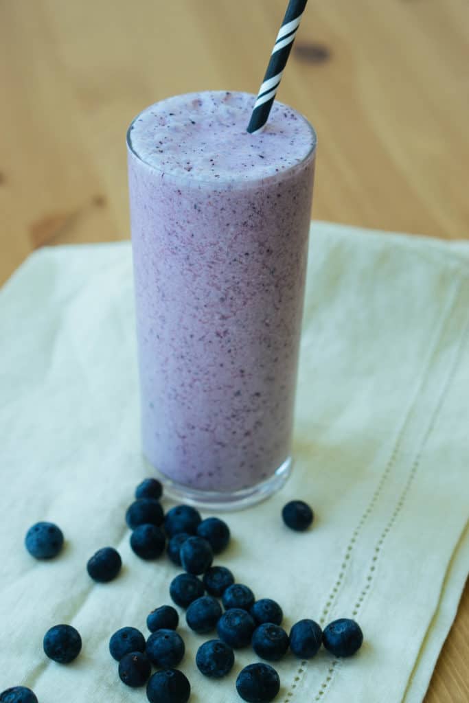 A purple smoothie with blueberries scattered around it. - eggless recipe