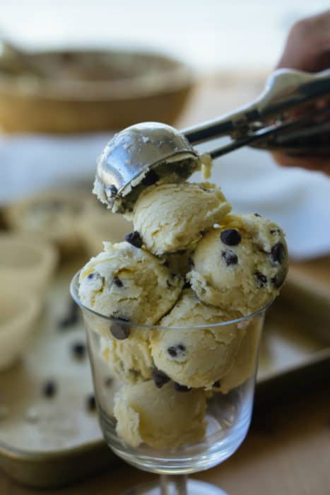 keto chocolate chip cookie dough fat bombs being scooped into a serving glass