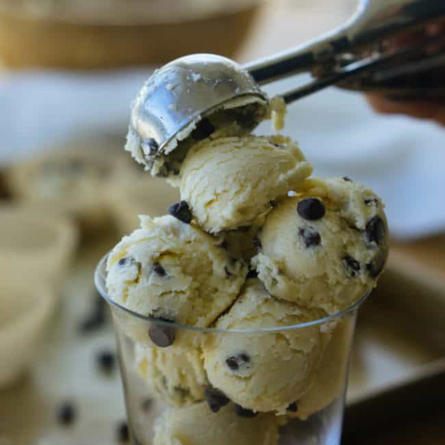 Keto Cookie Dough keto chocolate chip cookie dough fat bombs being scooped into a serving glass