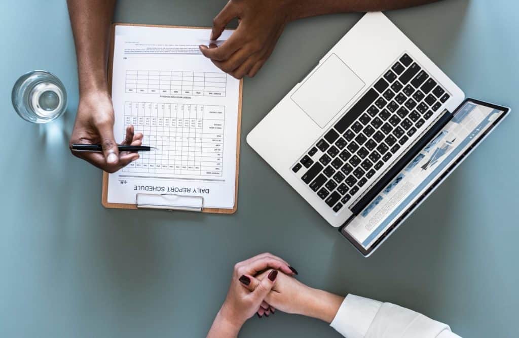 overhead picture of a doctor asking questions and writing down answers on a clipboard