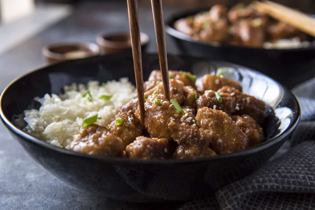 dairy free keto dairy free keto sweet and sour pork being eaten with chopsticks