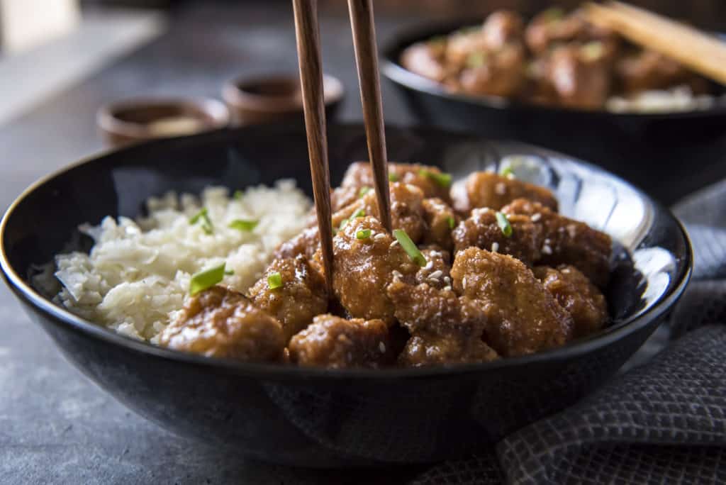 dairy free keto sweet and sour pork being eaten with chopsticks