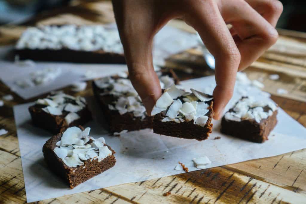 dairy free keto someone picking up a slice of dairy free keto fudge