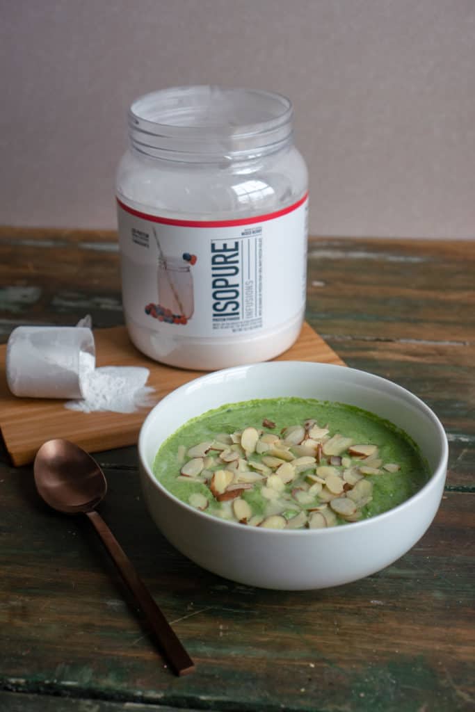 A smoothie bowl sitting alongside the tub of protein powder used to make it. 