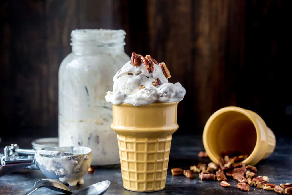 Butter Pecan ice cream served up near a handful of pecans to top with