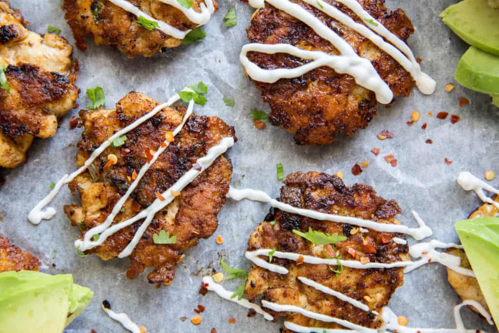 keto chicken nuggets on parchment paper with sauce on top