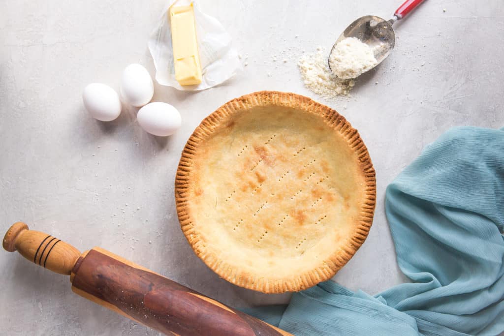 keto pie crust perfectly baked with eggs butter and a rolling pin