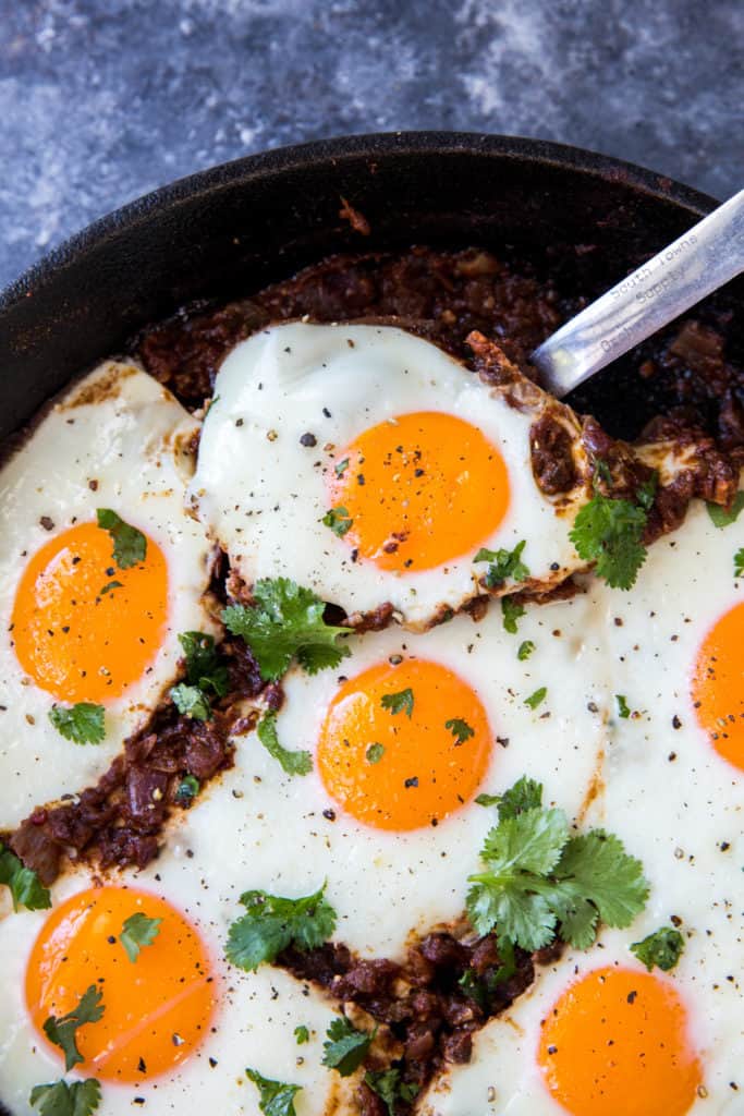 indian-eggs-close-scoop A cooked Indian Egg being scooped out of a cast iron skillet using a metal spoon