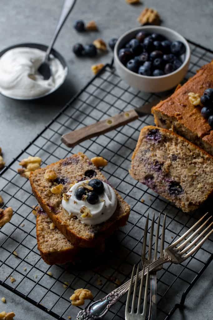 Sliced poundcake surrounded by cream and blueberries