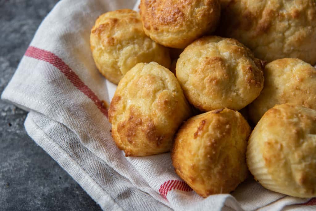 A basket of air fryer biscuits served over a white and red kitchen towel