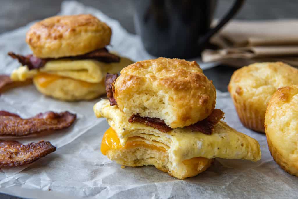 keto breakfast sandwich on parchment paper with a bite taken out