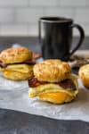 breakfast biscuit sandwich with coffee cup in background