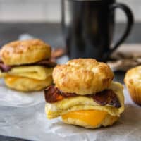 breakfast biscuit sandwich with coffee cup in background
