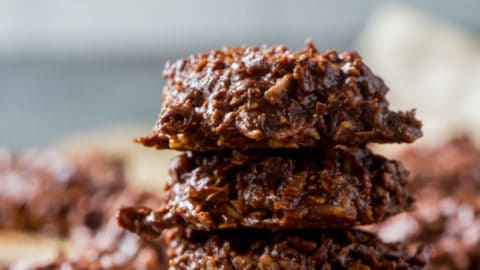 chocolate keto no bake cookies stacked on top of each other with pecans in the background
