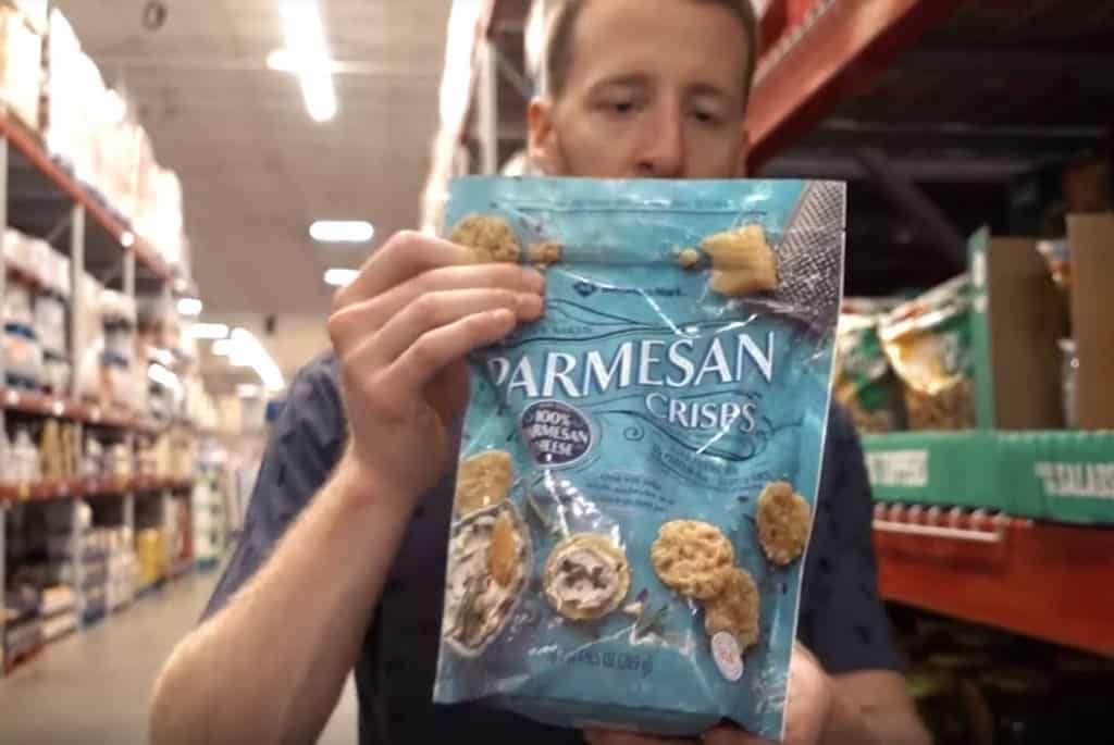 A man holding a large bag of Parmesan Crisps at Sam's Club. 