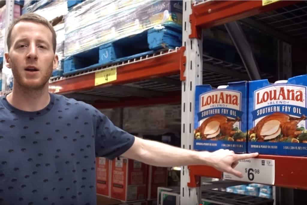 A man pointing to a bulk bottle of frying oil at Sam's Club.