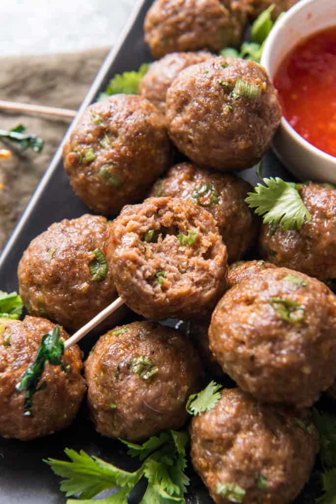 meatballs on a rectangle plate with a bite out of one of them