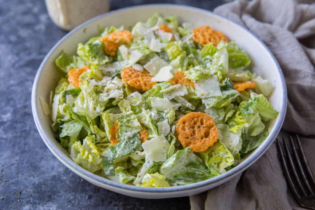 Keto Caesar Dressing a Caesar salad topped with homemade keto Caesar dressing and a fork