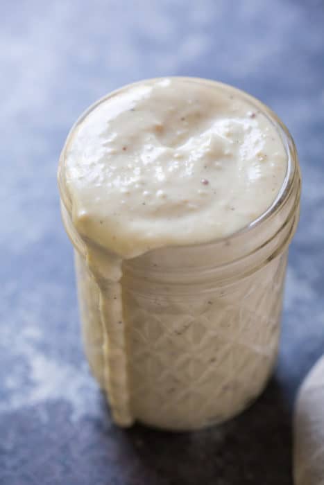 a glass jar filled with homemade keto caesar dressing