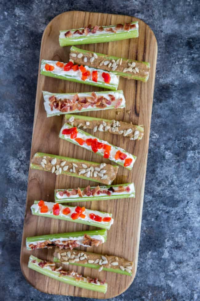 Stuffed celery three ways displayed on a wood cutting board