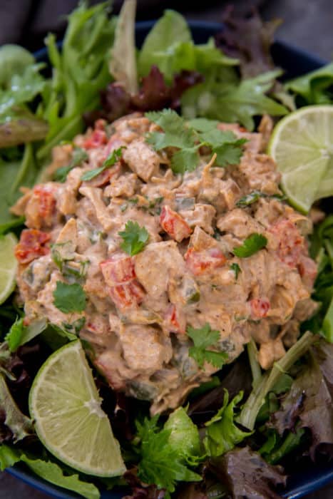 fajita style keto chicken salad on top of a bed of lettuce with lime wedges for garnish