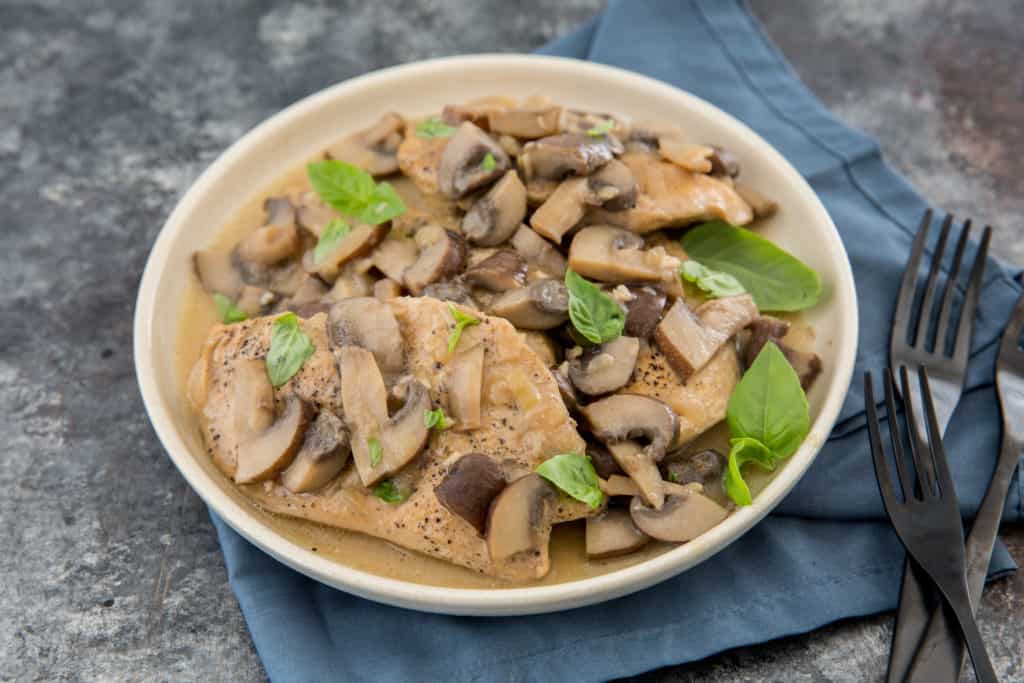 instant pot chicken marsala served on a white plate garnished with basil