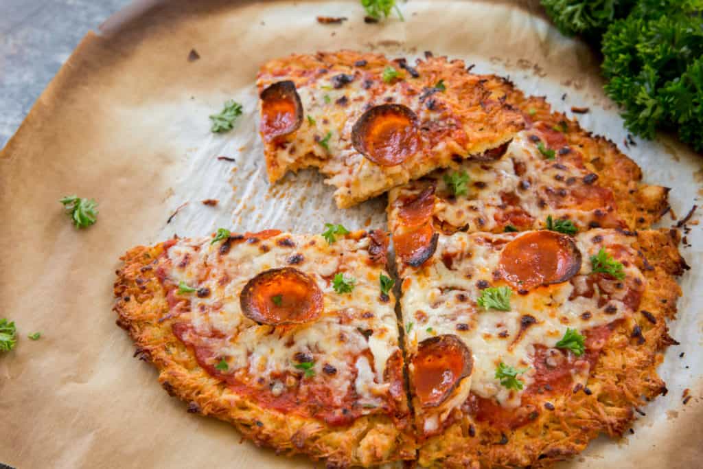 chicken crust pizza bite taken out of a pizza slice