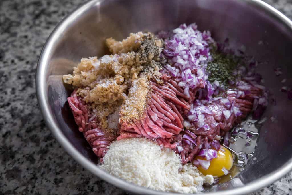 the ingredients to make a keto meatloaf in a metal bowl
