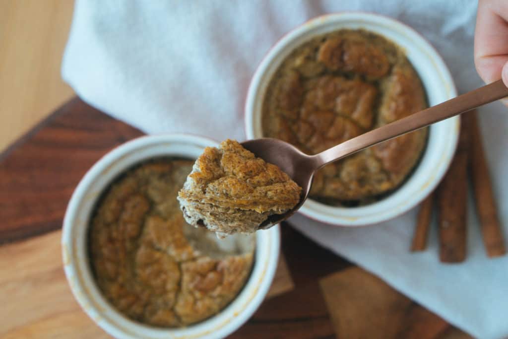 spoon scooping baked chia rice pudding from ramekin 