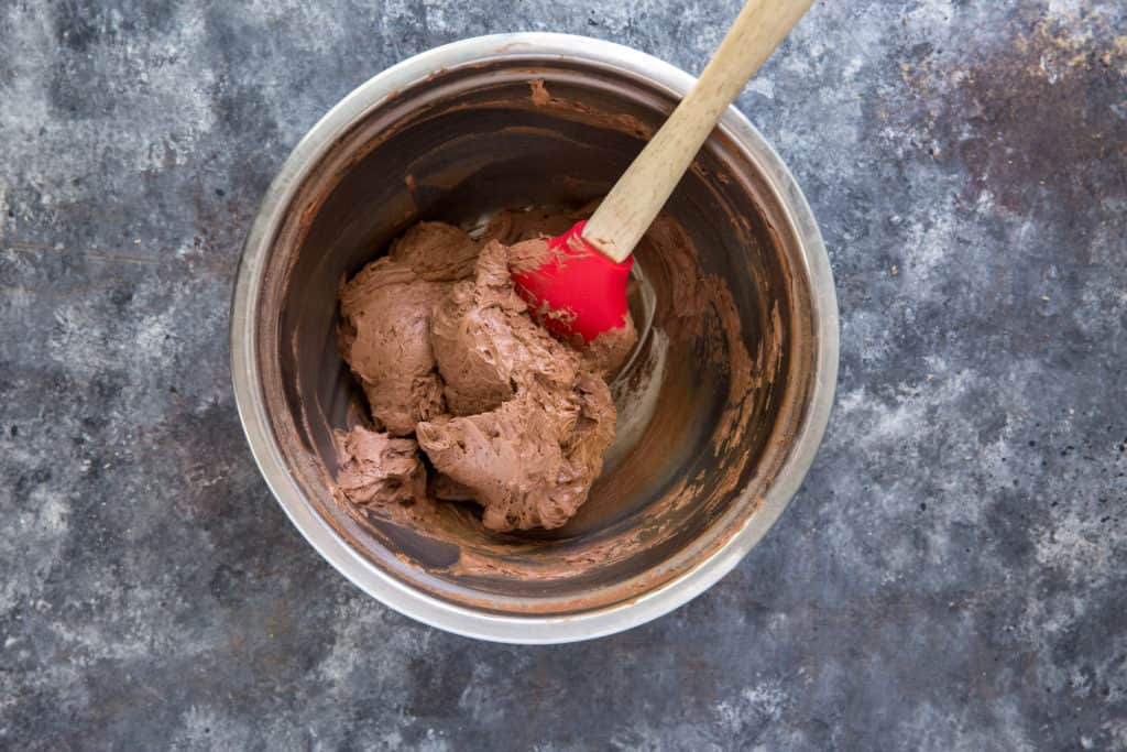 gluten free cupcakes frosting in a large mixing bowl with a spatula