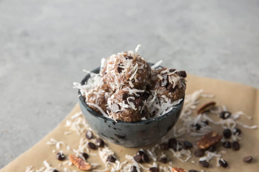 bowl of keto energy balls with coconut flakes and chocolate chips