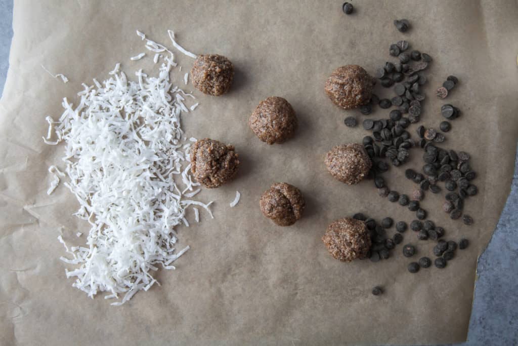 keto energy balls on parchment paper with coconut flakes and low carb chocolate chips