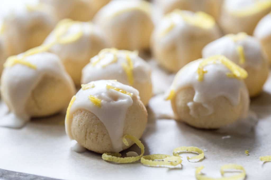 keto lemon cookies baked with a lemon glaze topping and lemon zest for garnish on parchment paper