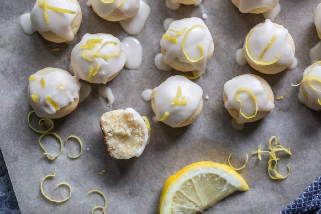 Lemon cookies on a piece of parchment paper after being glazed