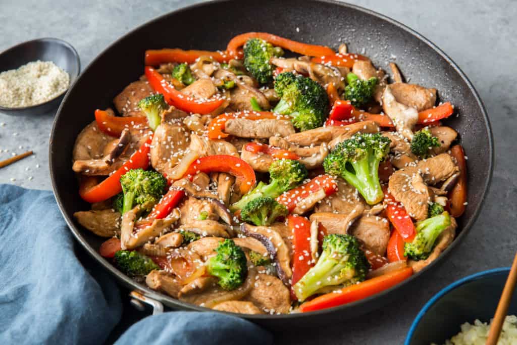 keto chicken stir fry ready to serve and topped with sesame seeds.