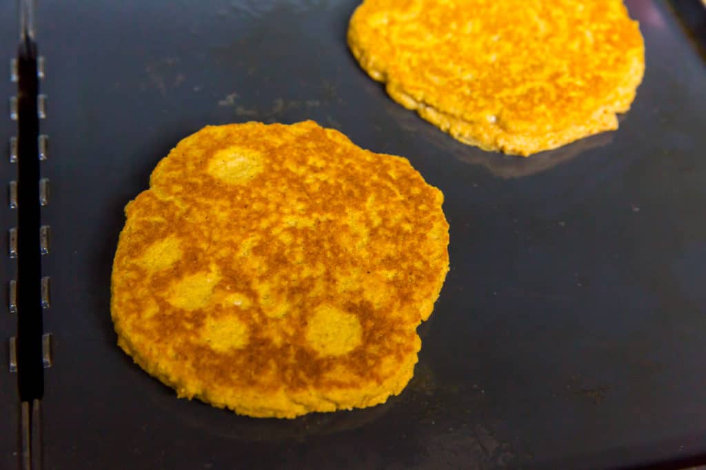 keto pumpkin pancakes pancake flipped on a griddle